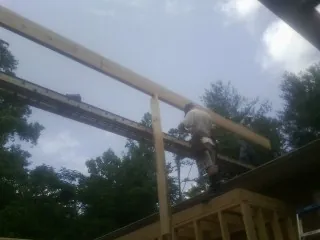 Carpenter setting a ridge beam over a new addition frame — Ice Dam Removal by Roofing Brothers in Eagle Mountain