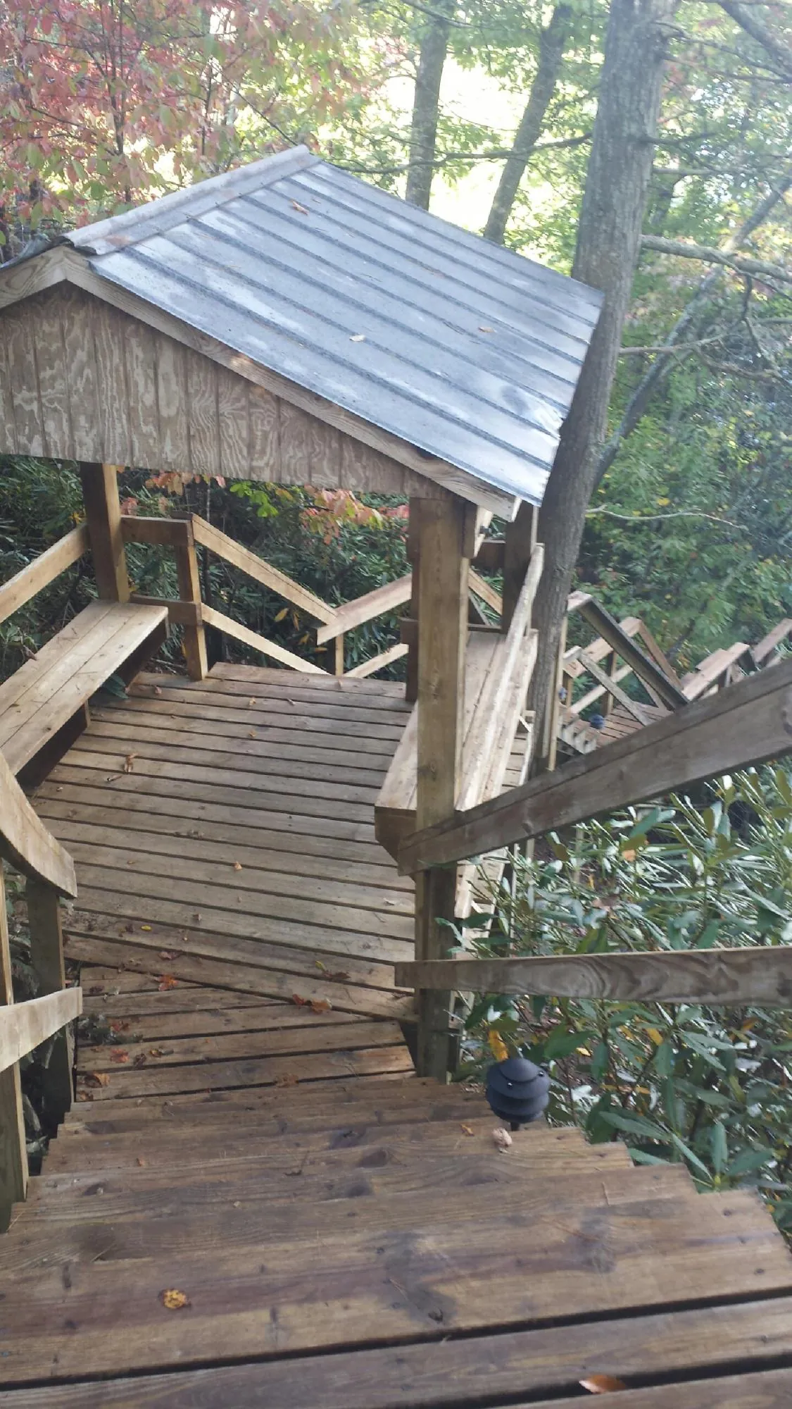Metal roofed shelter over wooden steps on a wooded walkway — Skylight Repair & Installation work by our crew in Eagle Mountain
