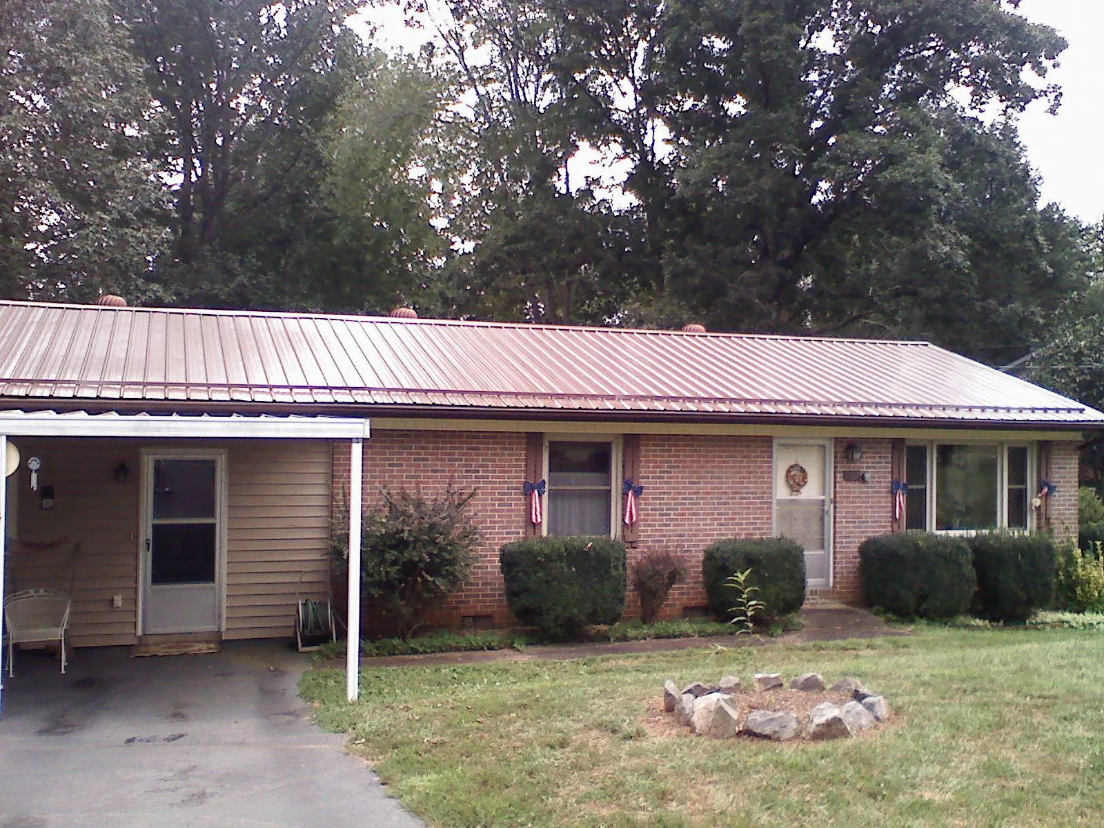 Bronze metal roof and carport on a brick ranch home — Roof Repair work by our crew in Eagle Mountain