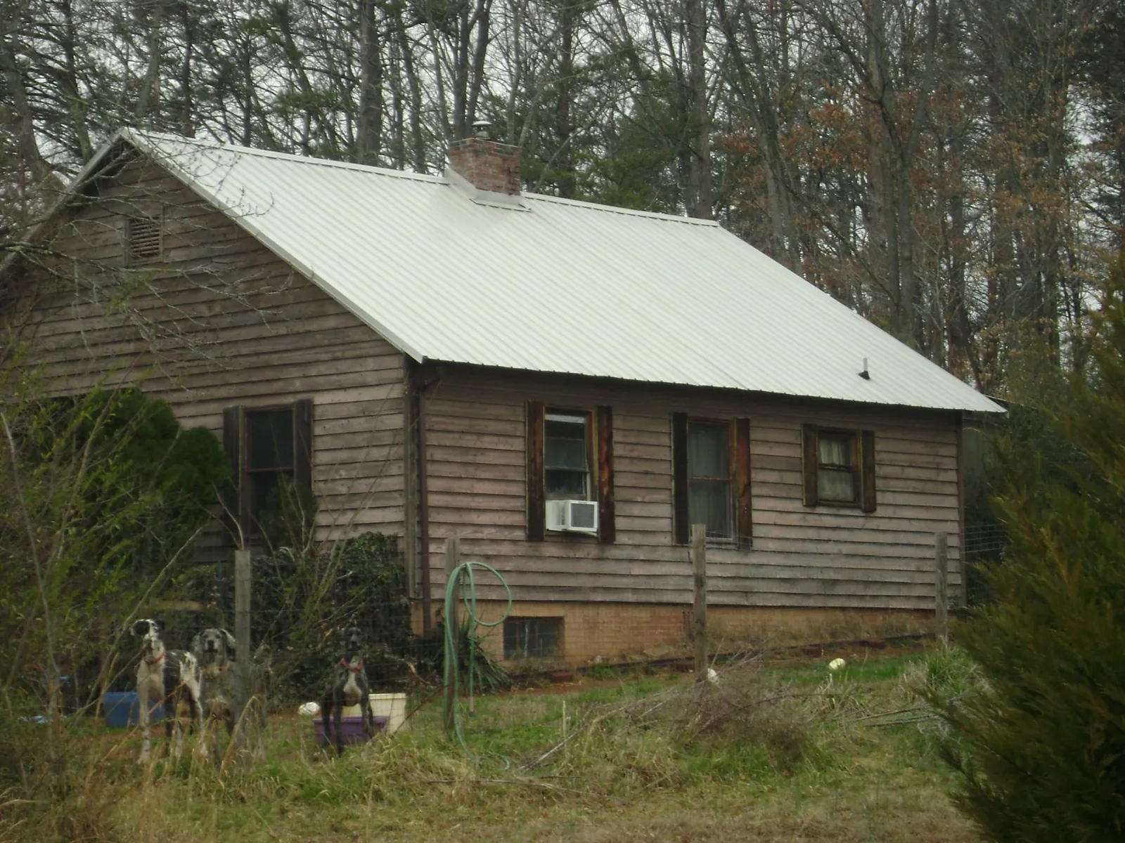 White metal roof on an old wood sided farmhouse, from a Metal Roof Installation job in Eagle Mountain